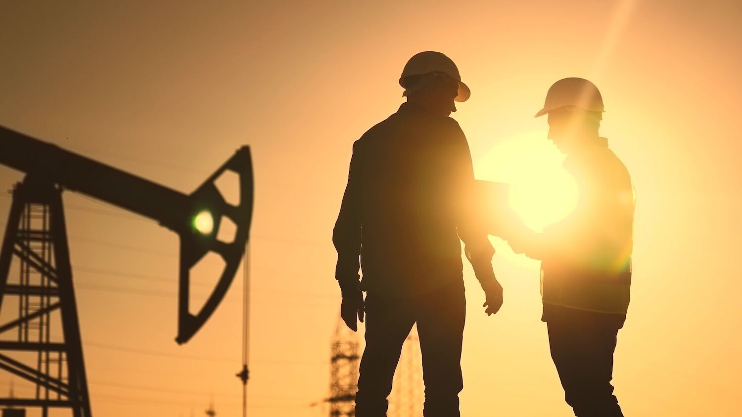 Two silhouetted oil workers.